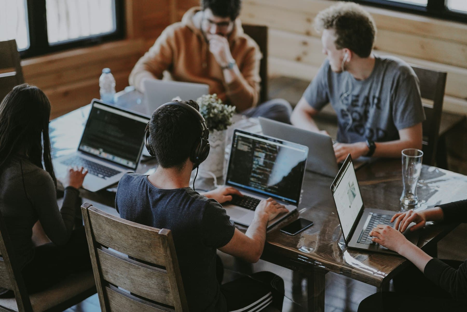 Equipo de trabajo reunido alrededor de una mesa con computadoras